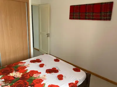 a bed with red roses on it in a room at Prédio IFH in Vila do Maio