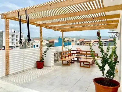 a wooden pergola with tables and benches on a patio at Casa Uta in Tarrafal