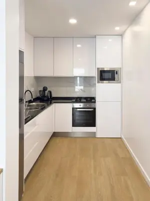 a kitchen with white cabinets and stainless steel appliances at Cozy 1-bdr apt, Cidadela - LCGR in Praia