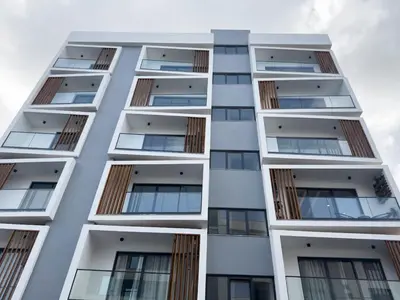 a tall white apartment building with windows at Cozy 1-bdr apt, Cidadela - LCGR in Praia