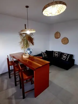 a living room with a table and a couch at Kasa surf in Porto Novo