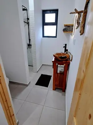 a bathroom with a small table and a window at Kasa surf in Porto Novo