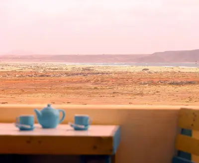 a table with two cups on top of the beach at Flat 4U in Santa Maria