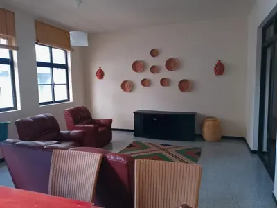 a living room with couches and a tv on a wall at Essencia Sterra in Praia
