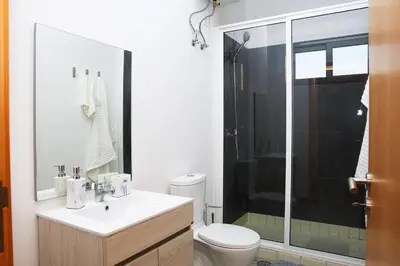 a bathroom with a toilet and a glass shower at Comfort and Peace in Santa Maria