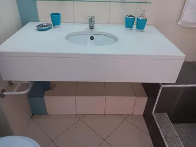 a bathroom with a white sink with blue cups on it at Vila Verde House in Santa Maria
