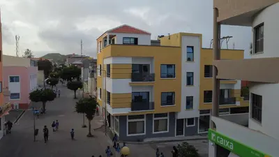 a yellow and white building on a city street at Apart'hotel Assomada in Assomada