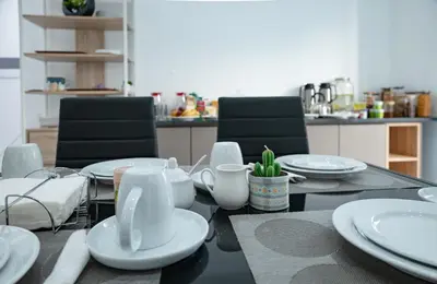 a dining table with white plates and utensils on it at Apart'hotel Assomada in Assomada