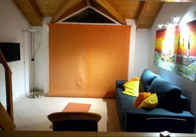 a living room with a blue couch and an orange wall at Soleil A5 - Lovely and central apartment in Santa Maria