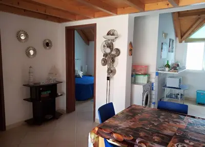 a dining room with a table and blue chairs at Soleil A5 - Lovely and central apartment in Santa Maria