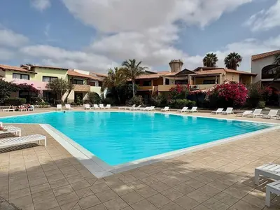 a large swimming pool with lounge chairs in a resort at Porto Antigo, o Paraíso na ilha do Sal, no centro de Sta Maria in Santa Maria