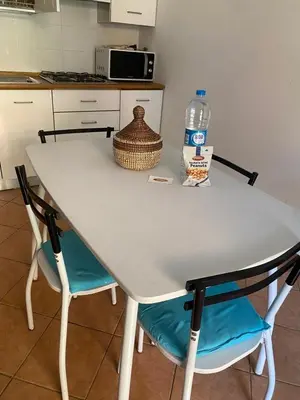 a white table with two chairs and a bottle of water at Porto Antigo, o Paraíso na ilha do Sal, no centro de Sta Maria in Santa Maria