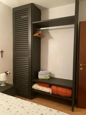 a bedroom with a black closet with folded towels at Porto Antigo, o Paraíso na ilha do Sal, no centro de Sta Maria in Santa Maria