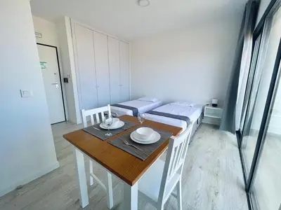 a dining room with a table and white chairs at Studio Medsal in Santa Maria