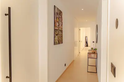 a hallway with white walls and a painting on the wall at Nusa Apartments Monte Cara in Mindelo