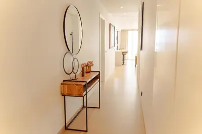 a hallway with a mirror and a wooden table at Nusa Apartments Monte Cara in Mindelo