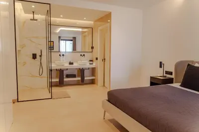 a bedroom with a bed and a bathroom with a sink at Nusa Apartments Monte Cara in Mindelo
