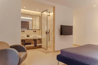 a bedroom with a bed and a bathroom with a sink at Nusa Apartments Monte Cara in Mindelo