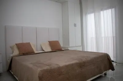 a bedroom with a large bed with two chairs at Fresh One Too Apartment in Praia