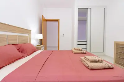a bedroom with a large bed with two towels on it at New building - 1 min away from the main road in Santa Maria