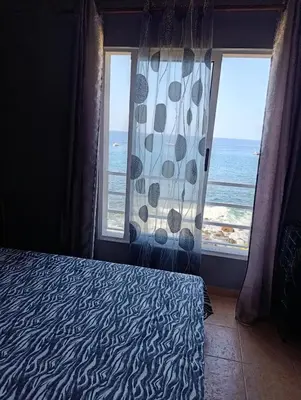 a bedroom with a bed and a window with the ocean at B&B Casa Boho