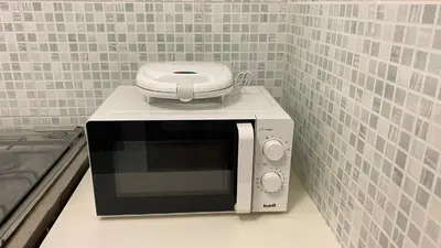 a microwave sitting on top of a counter at Airport Residence - Vila Acácia I in Praia