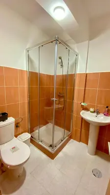 a bathroom with a shower and a toilet and a sink at Airport Residence - Vila Acácia I in Praia