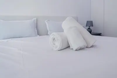 a pile of towels on a white bed at Yes Rooftop, Private Pool & Sea View, Cidadela in Praia