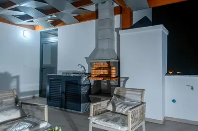 a patio with two chairs and a stove at Yes Rooftop, Private Pool & Sea View, Cidadela in Praia