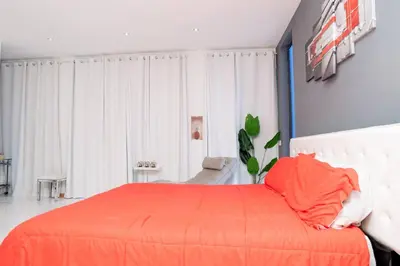 a bedroom with a bed with an orange blanket at Kretxeu Luxury Villa in Praia