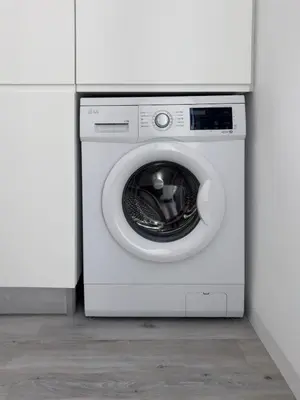 a white washing machine in a white room at 2-bdr bright apt central street cidadela - LCGR in Praia