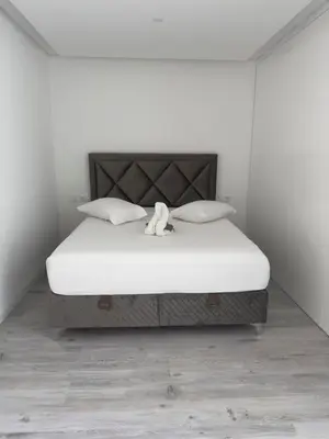 a white bedroom with a bed with a teddy bear on it at 2-bdr bright apt central street cidadela - LCGR in Praia