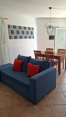 a blue couch with red pillows in a living room at Star House Murdeira, Sal Island, Cape Verde in Beirona