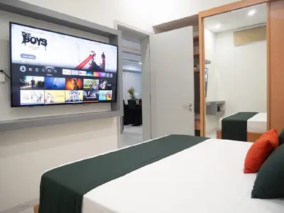 a bedroom with a bed and a tv on a wall at Top-Level Pool in Praia