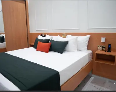 a bedroom with a large white bed with colorful pillows at Top-Level Pool in Praia