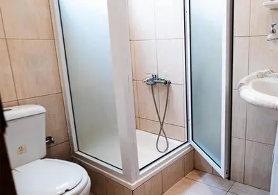 a bathroom with a shower with a toilet and a sink at Residencial Mendes in Tarrafal