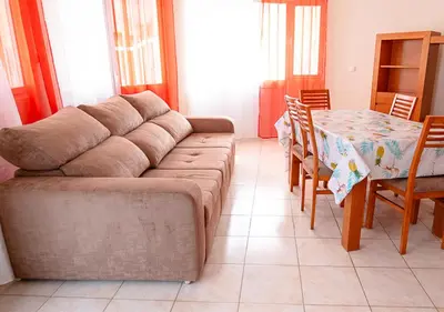 a living room with a couch and a table with chairs at Residencial Mendes in Tarrafal
