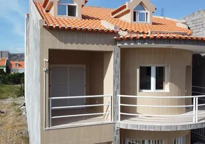 a house with a balcony and a roof at Residencial Mendes in Tarrafal