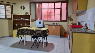 a kitchen with a table and two stools at Kaza Manata in Praia