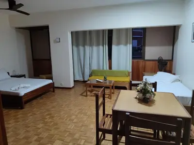 a hotel room with two beds and a table and chairs at Residencial P&P in Mindelo