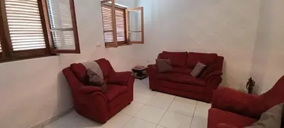 a living room with two red chairs and windows at Casa Azul in Paul
