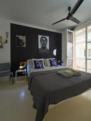 a bedroom with a large bed with blue pillows at Casa Albacora in Sal Rei