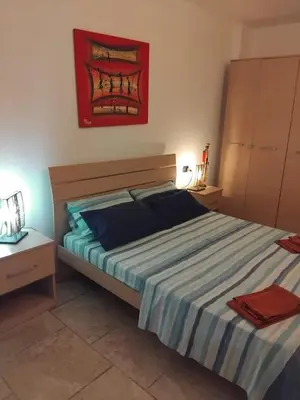 a bedroom with a large bed with a striped bedspread at Moradias No Stress in Santa Maria