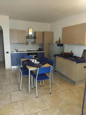 a kitchen with a table and chairs and a refrigerator at Moradias No Stress in Santa Maria