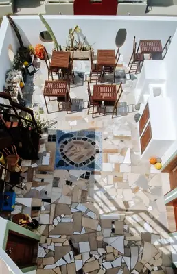 a lobby with chairs and a floor covered in tiles at Casa Cesaria Guest House in Sal Rei