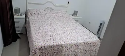 a bedroom with a bed with a flowered blanket on it at Casa Flor Apartment in Ribeira Grande