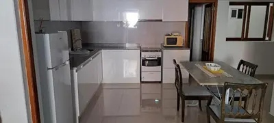 a kitchen with a table and a white refrigerator at Casa Flor Apartment in Ribeira Grande