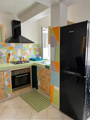 a kitchen with a black refrigerator in a colorful kitchen at Rosa dei venti 3 in Santa Maria