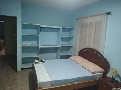 a bedroom with a bed with blue walls and shelves at kaza sz in Praia