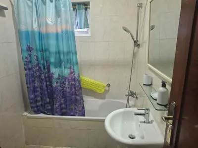 a bathroom with a sink and a tub with a shower curtain at kaza sz in Praia